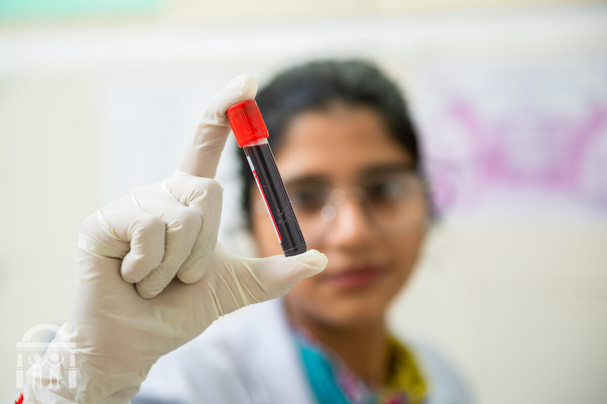 Blood sample vial being examined by lab technician at Guru Nanak Mission Hospital Dhahan Kaleran near Banga