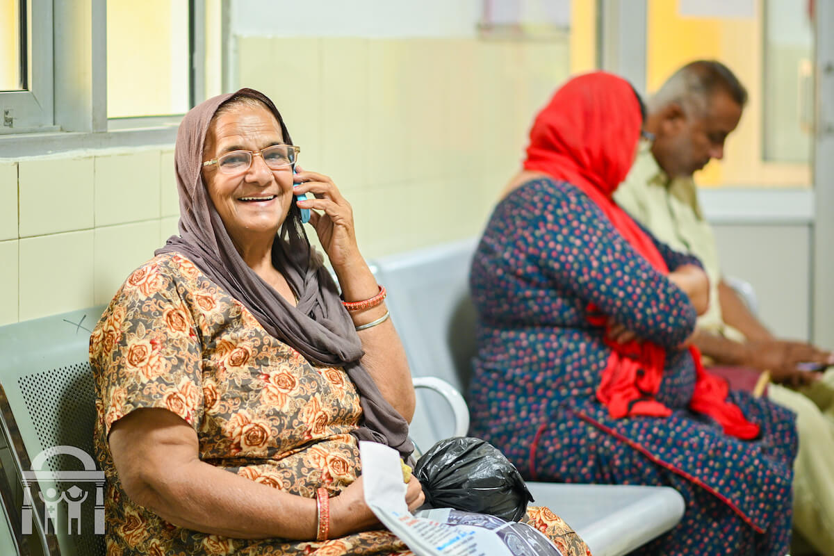 Woman in waiting room on the phone at Guru Nanak Mission Hospital Dhahan Kaleran near Banga and Phagwara